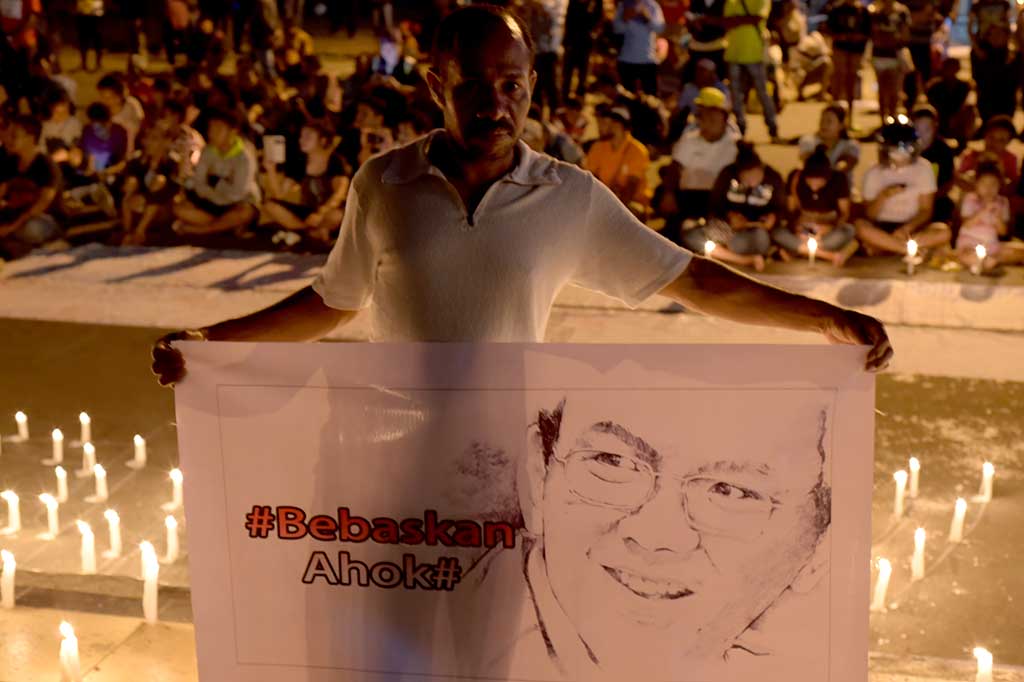 Seorang warga memegang spanduk bertuliskan 'Bebaskan Ahok' dalam aksi seribu lilin untuk Basuki Tjahaja Purnama (Ahok) di Taman Imbi pusat Kota Jayapura, Papua. ANTARA/Indarayadi TH