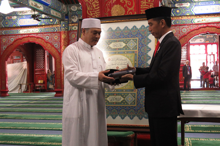 Presiden Joko Widodo memberikan cendera mata berupa songkok dan sarung kepada imam Masjid Niujie, Beijing, Ali Yang Gunjun.