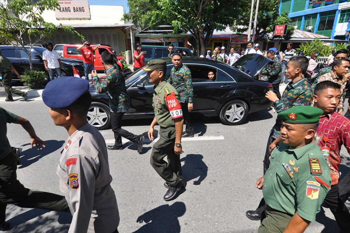 Presiden melihat dari balik jendela mobil saat warga menyambutnya di Palu. Ribuan warga dan pelajar antusias menyambut Presiden yang berkunjung ke Palu untuk membuka Kongres PMII.
