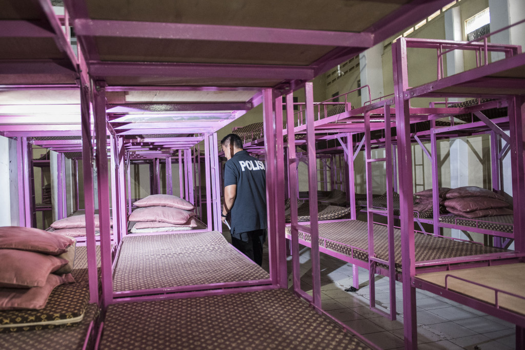 Polisi memeriksa lemari kayu tempat para calon TKI ilegal menyimpan barang-barang pribadi mereka. Ada puluhan rancang susun di dalam ruang penampungan.