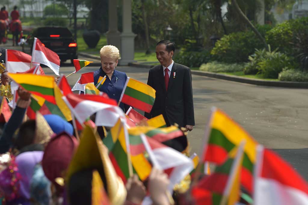 Presiden Lithuania disambut sejumlah pelajar yang mengenakan pakaian adat Indonesia dan membawa bendera kedua negara.