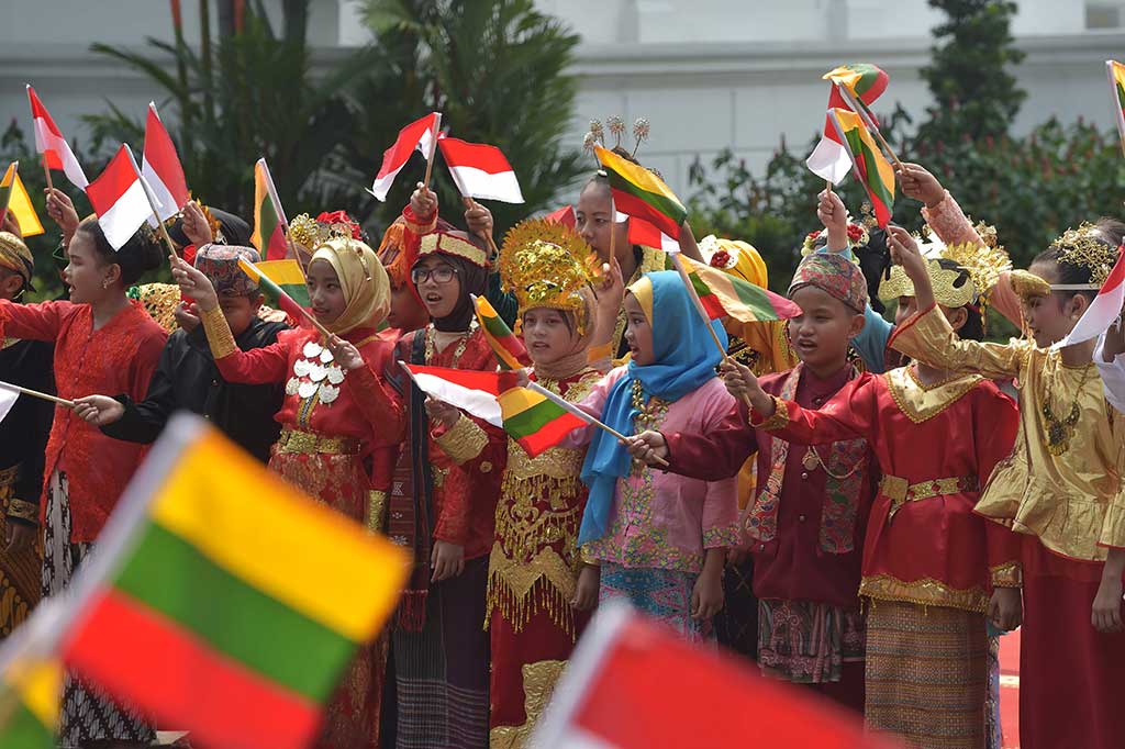 Para pelajar yang memakai baju adat berbagai daerah sambil mengimbarkan bendera kebangsaan kedua negara ikut dalam upacara penyambutan ini.