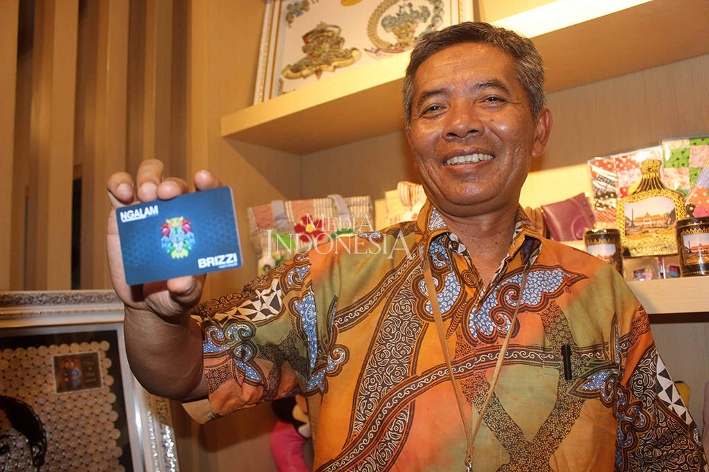 Senior Executive Vice Presiden UKM & Konsumer BRI Supari menunjukkan Brizzi Ngalam atau uang isi ulang BRI yang akan digunakan untuk transaksi dalam Parade UMKM di Kota Malang, Jawa Timur.
