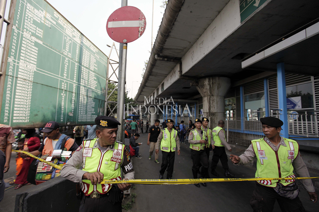 Petugas Kepolisian berjaga di kawasan tempat kejadian perkara ledakan bom di Terminal Kampung Melayu, Jakarta Timur.