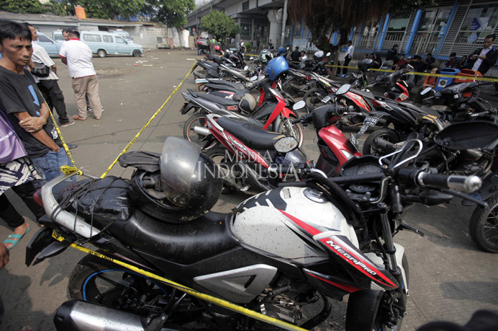 Sepeda motor yang diduga milik korban diamankan dengan garis polisi di kawasan tempat kejadian perkara ledakan bom.
