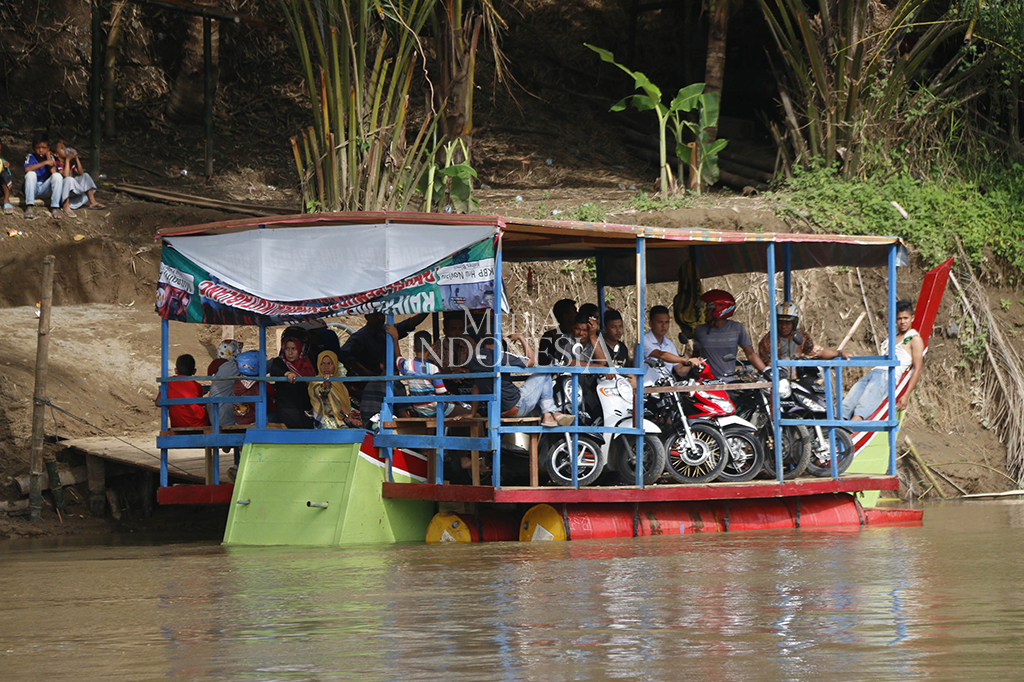Sejumlah warga termpaksa menggunakan getek (angkutan perahu) untuk menyebrang dan mengangkut kendaraan.