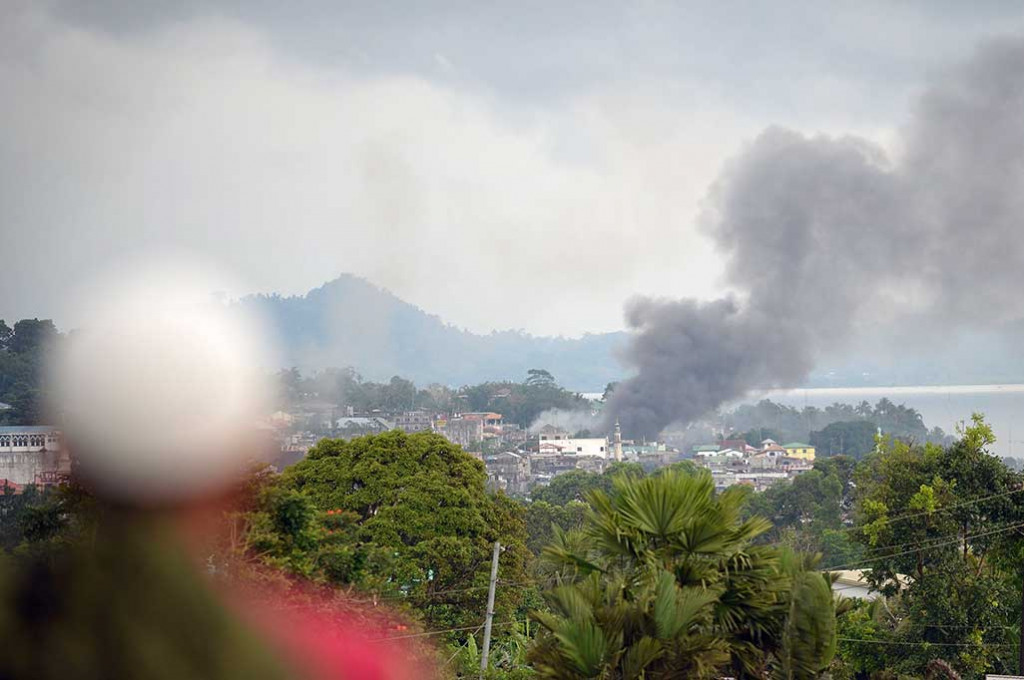 Asap membubung ke angkasa di dekat sebuah pasar setelah helikopter tempur militer Filipina menembakkan roket ke posisi kelompok milisi Maute di Kota Marawi, Mindanao, Kamis (25/5/2017). 
