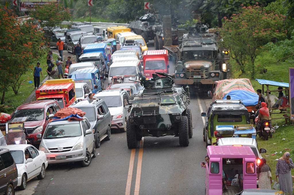 Armada personel lapis baja dan truk miiter bergerak di antara kendaraan warga yang terjebak kemacetan yang berusaha eksodus keluar dari Kota Marawi. 