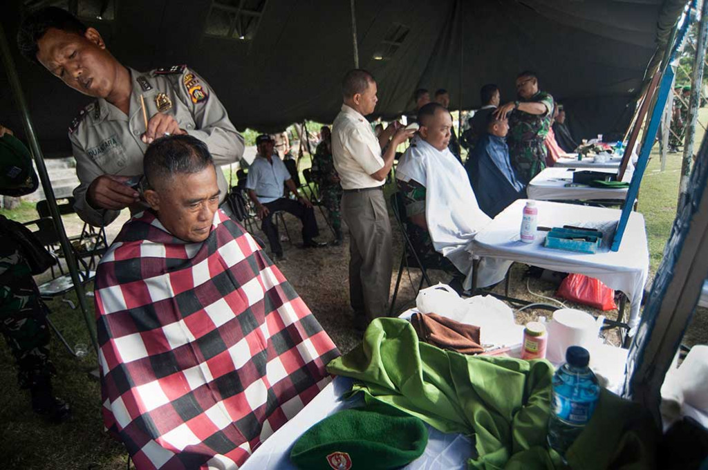 Seorang anggota polisi mencukur prajurit TNI sebagai bentuk soliditas aparatur negara disela apel Solidaritas Kebangsaan dan Kirab Pancasila di Lapangan Puputan Margarana, Denpasar.