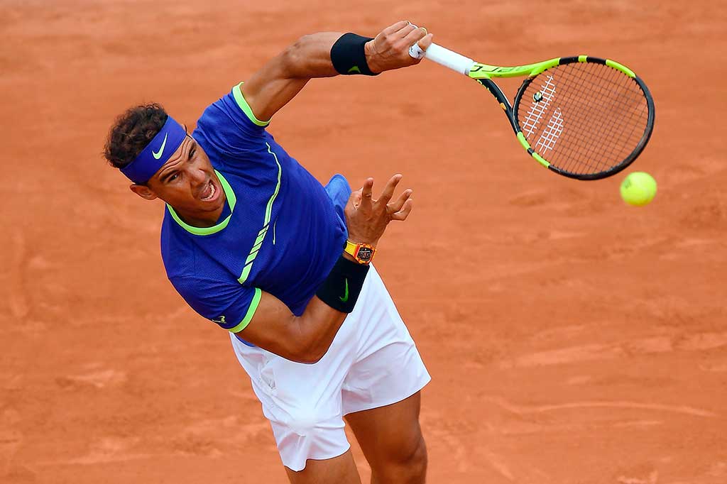 Petenis Spanyol Rafael Nadal melancarkan servis ke arah petenis tuan rumah Benoit Paire pada laga pembuka Pranis Terbuka, Senin (29/5/2017) waktu setempat.