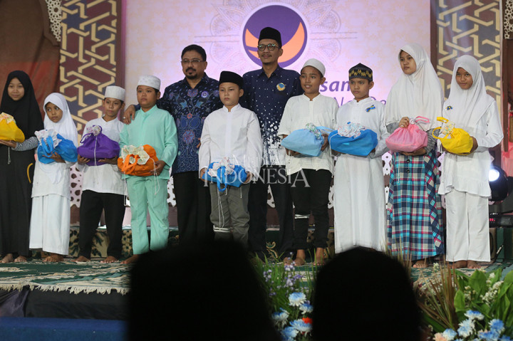 Ketua Bidang Industri dan Perdagangan Partai NasDem Zulfan Lindan dan Ketua Bidang Agama dan Masyarakat Adat Partai NasDem Hasan Aminuddin memberikan bingkisan secara simbolis kepada anak-anak panti asuhan saat acara Buka Puasa Bersama Keluarga Besar Partai NasDem di DPP Partai NasDem, Jakarta.