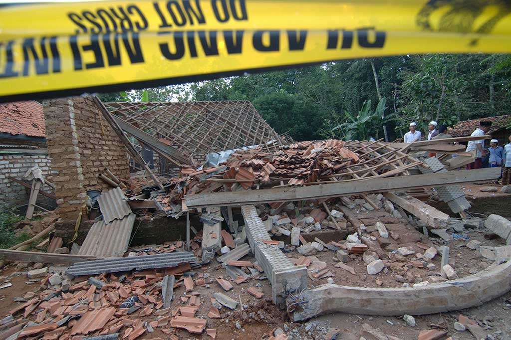 Warga menyaksikan rumah yang ambruk akibat ledakan bubuk petasan di Desa Ambender, Pegantenan, Pamekasan, Jawa Timur, Rabu (31/5/2017).