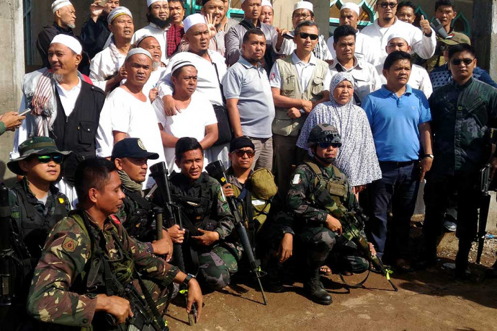 Sejumlah WNI yang tergabung dalam jemaah tablig berfoto bersama dengan tim KBRI dan Angkatan Bersenjata Filipina sebelum dievakuasi dari Marawi City.