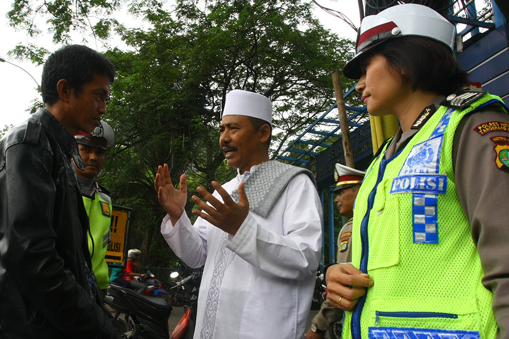 Seorang Ustadz yang juga anggota Polres Metropolitan Tangerang Kota, memberikan Tausiyah kepada pengendara motor yang kedapatan mengendarai motor tidak membawa SIM saat razia Ramadania di Cikokol, Tangerang, Banten.