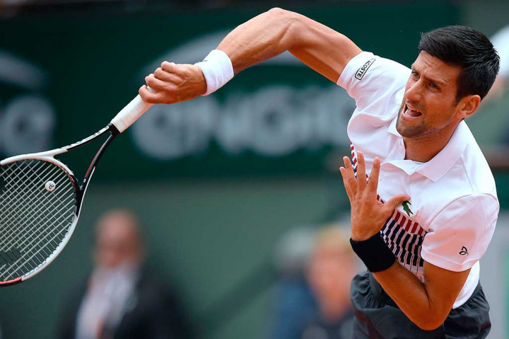 Petenis Serbia Novak Djokovic melancarkan servis ke arah lawannya Diego Schwartzman asal Argentina di Roland Garros, Jumat (2/6/2017) waktu setempat.