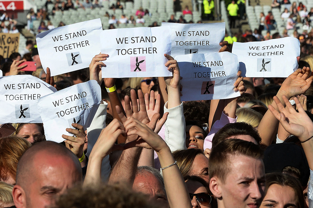 Para penonton pun mengangkat tanda 'We stand together' dan 'For our angels' selama konser berlangsung.
