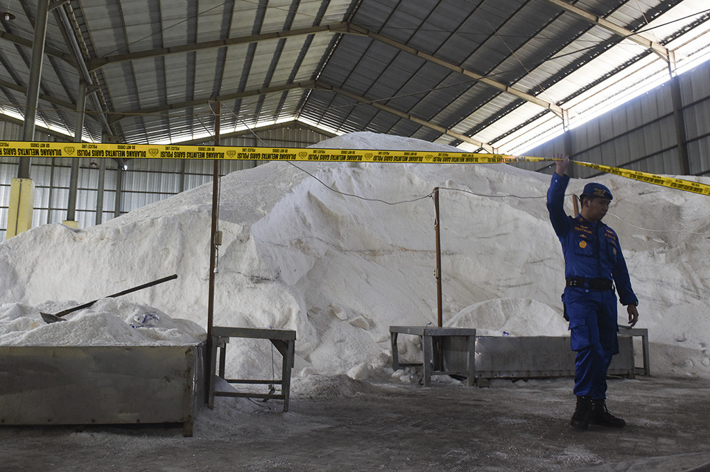 Petugas memeriksa garam milik PT Garam (persero) yang disegel di dalam gudang.