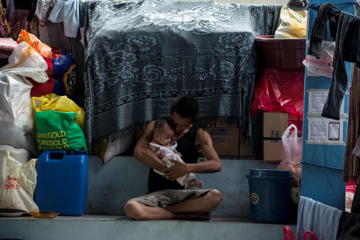 Seorang ayah menimang bayinya di bilik pengungsiannya. Jumlah korban tewas dari pihak militer dan milisi sekitar 200 orang. 