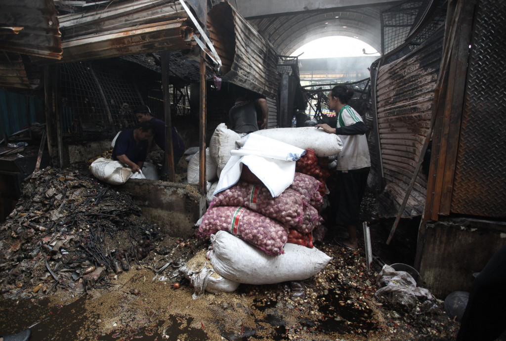 Tumpukan bawang merah berhasil diselamatkan dari puing kios yang habis terbakar.