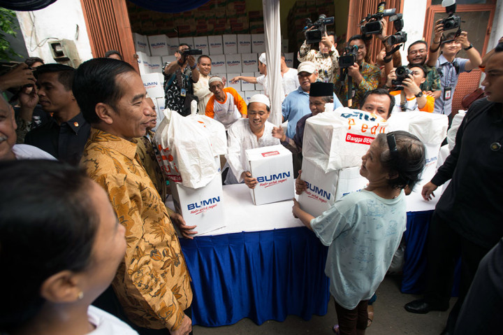 Presiden Jokowi menyaksikan pembagian sembako kepada warga.