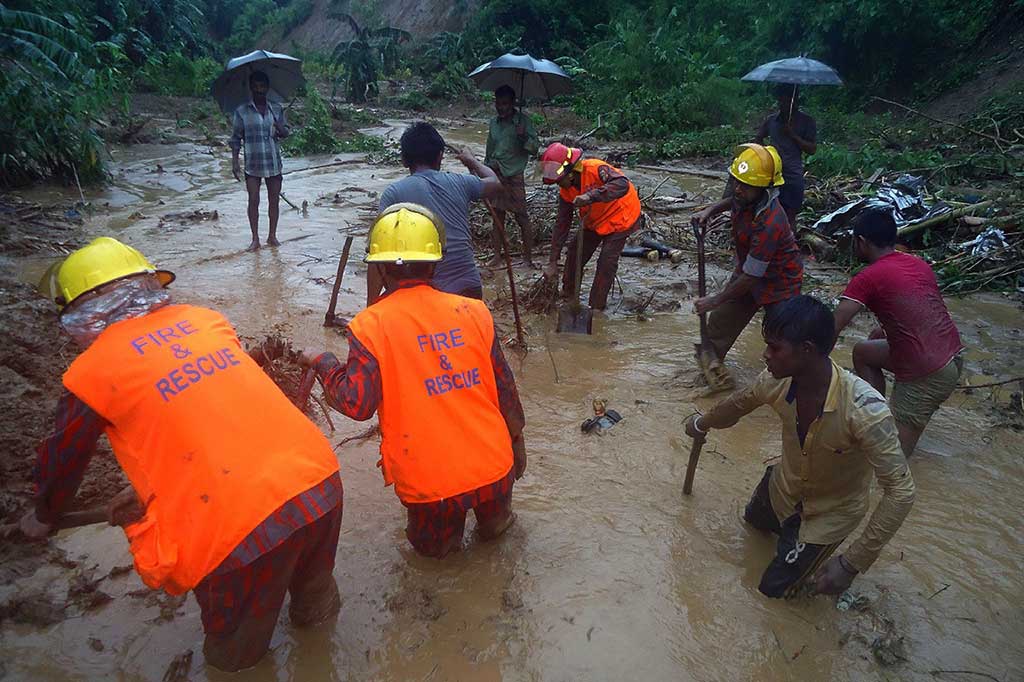 Petugas pemadam kebakaran dibantu warga berusaha mencari korban yang diduga tertimbun tanah longsor di wilayah  Bandarban, Bangladesh, Selasa (13/6/2017).