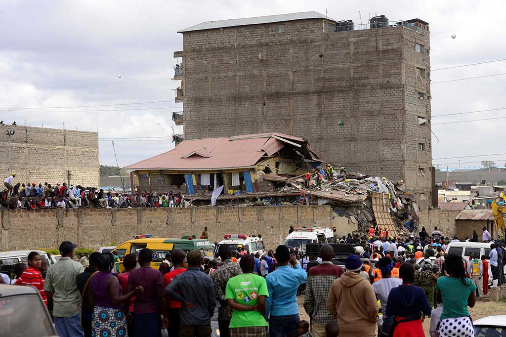 Ratusan warga melihat petugas penyelamat berusaha mengevakuasi warga yang terjebak dalam reruntuhan bangunan tujuh lantai di Embakasi, Nairobi, Selasa (13/6/2017).
