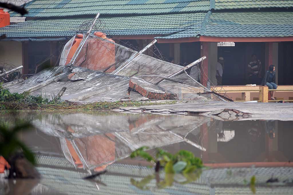 Sejumlah warga binaan berada di samping dinding yang jebol akibat banjir di Lapas Klas IIA Jambi, Jambi, Rabu (14/6/2017).
