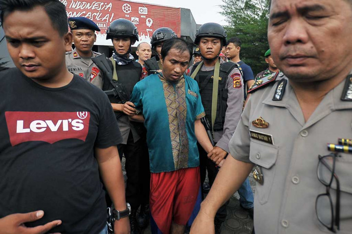 Petugas kepolisian menggiring salah seorang warga binaan yang berhasil ditangkap kembali. Belasan warga binaan yang kabur berhasil ditangkap pascajebolnya dinding lapas akibat banjir luapan sungai.