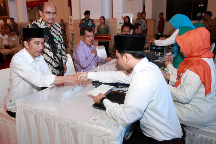 Presiden Joko Widodo dan Wapres Jusuf Kalla, didampingi Ketua Badan Amil Zakat Nasional (Baznas Bambang Sudibyo (kedua dari kiri) saat membayar zakat penghasilan kepada petugas Baznas di Istana Negara, Jakarta, Rabu (14/6/2017).