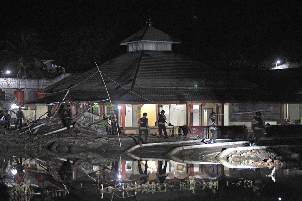 Aparat kepolisian berjaga di sekitar dinding Lapas Klas II A Jambi yang jebol akibat banjir di Jambi, Rabu (14/6) malam.