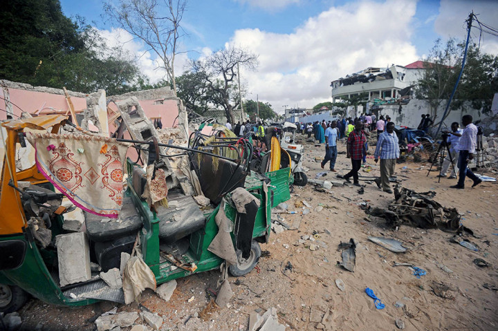 Warga berjalan di dekat lokasi serangan pria bersenjata di luar Restoran Pizza House, di Mogadishu, Somalia, Kamis (15/6/2017).