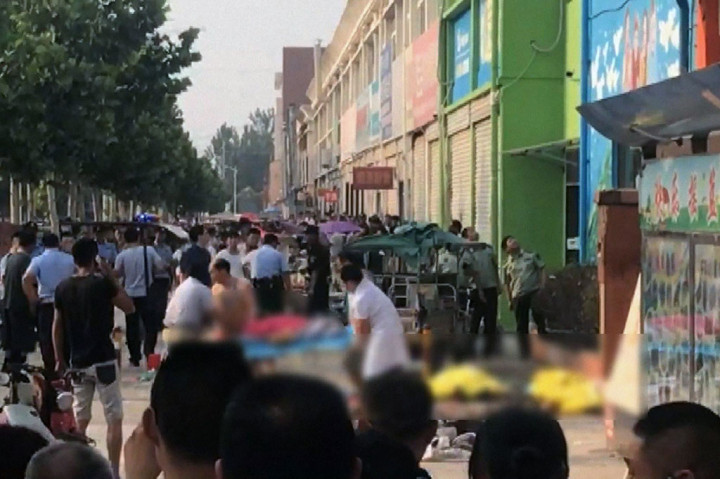 Petugas keamanan dan regu penyelamat terjun ke lokasi ledakan di depan gerbang sebuah taman kanak-kanak di Fengxian, Provinsi Jiangsu, China timur, Kamis (15/6/2017). AFP/CCTV