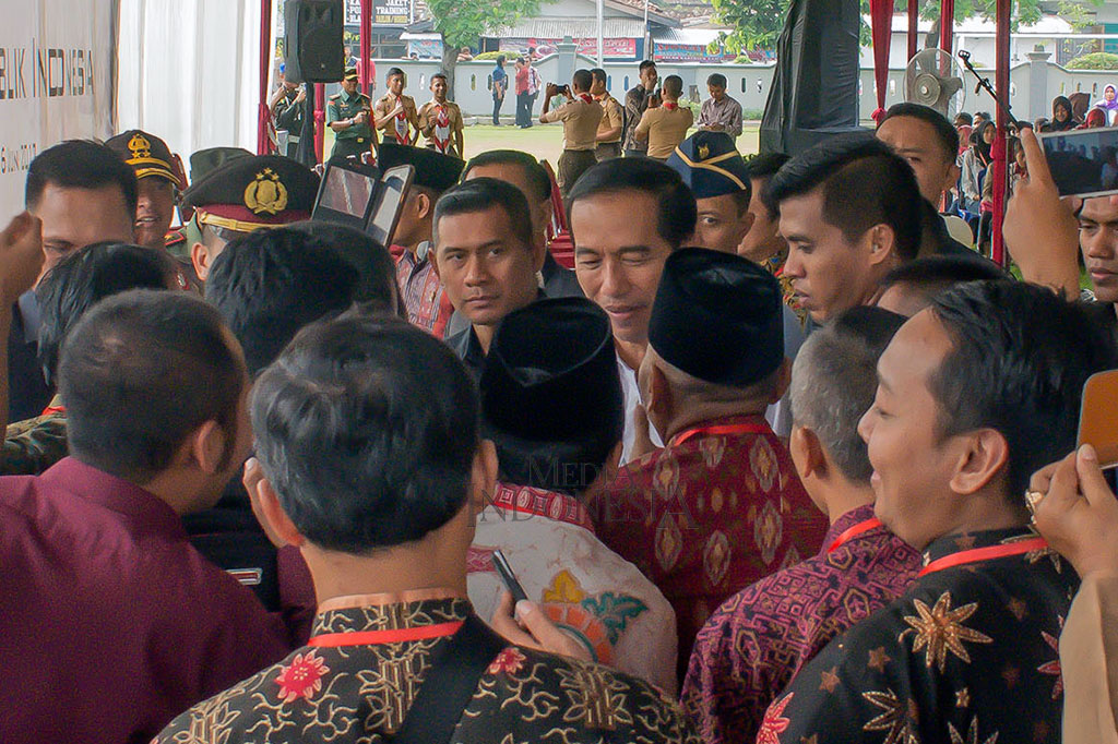 Warga berebut berjabat tangan dengan Presiden setelah acara pembagian KIP.