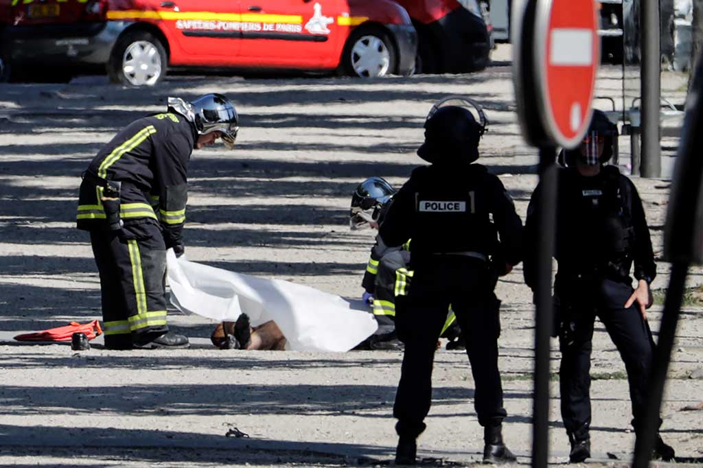 Polisi menutupi jenazah pelaku penyerangan di distrik perbelanjaan Champs-Elysees, Paris, Senin (19/6/2017) waktu setempat.