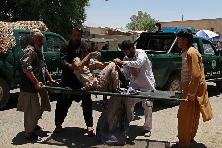 Warga mengevakuasi korban ledakan bom yang terjadi saat warga mengantre di bank untuk mengambil gaji untuk keperluan Idul Fitri. 