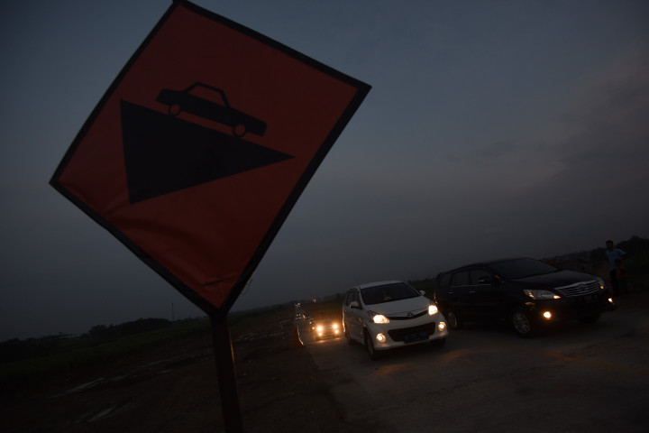 Rambu peringatan kondisi jalan yang naik dan turun. Malam sebelumnya jalur tol fungsional ditutup untuk perbaikan setelah sepanjang hari dilintasi ribuan kendaaan pemudik. 