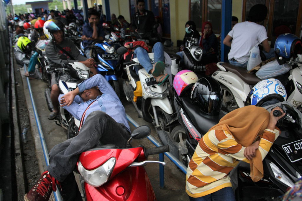 Beberapa pemudik beristirahat di atas sepeda motornya saat antre kapal ferry di Pelabuhan Amolengu Konawe Selatan, Sulawesi Tenggara. Pelabuhan ini gerbang menuju Muna, Muna Barat, Buton, Buton Tengah, Buton Selatan, Baubau dan Wakatobi dengan armada kapal ferry. ANTARA FOTO/Jojon
