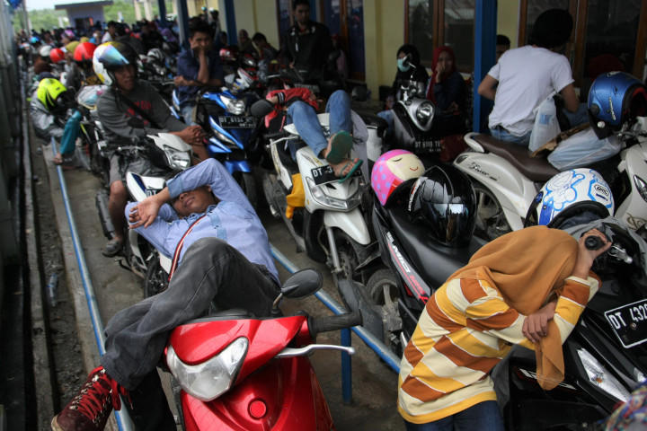 Beberapa pemudik beristirahat di atas sepeda motornya saat antre kapal ferry di Pelabuhan Amolengu Konawe Selatan, Sulawesi Tenggara. Pelabuhan ini gerbang menuju Muna, Muna Barat, Buton, Buton Tengah, Buton Selatan, Baubau dan Wakatobi dengan armada kapal ferry. ANTARA FOTO/Jojon
