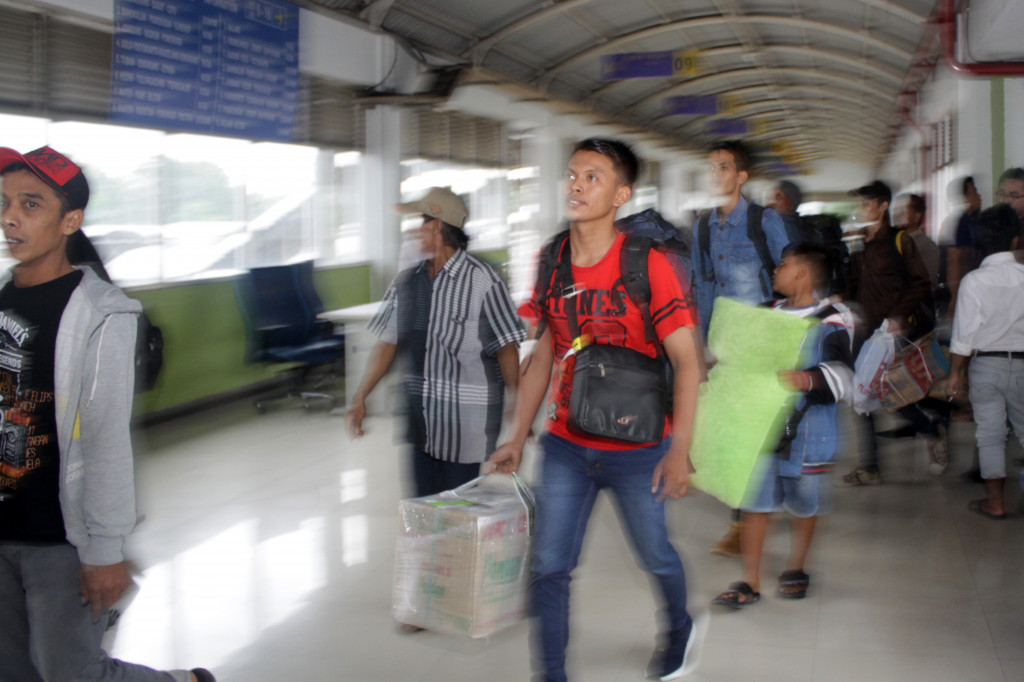 Seorang pemudik di Terminal Purabaya, Surabaya, bergegas menuju bus yang akan membawanya mudik. Hari ini merupakan puncak kepadatan di terminal bus terbesar di Jawa Tiimur tersebut. 