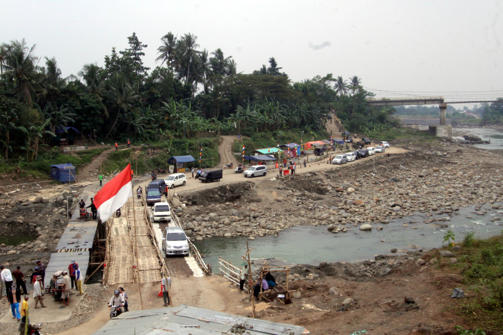 Ratusan kendaraan para pemudik bergiliran menyeberangi jembatan darurat di Cipamingkis, Jonggol, Kab. Bogor, Jawa Barat. Dua bulan lalu jembatan di jalur yang merupakan alternatif dari Jakarta menujuk Bandung, Cianjur dan sekitarnya itu patah.  ANTARAFOTO/Yulius Satria 