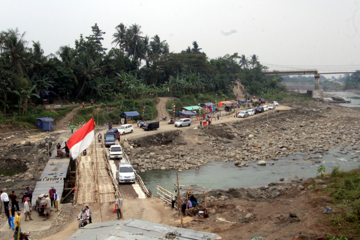 Ratusan kendaraan para pemudik bergiliran menyeberangi jembatan darurat di Cipamingkis, Jonggol, Kab. Bogor, Jawa Barat. Dua bulan lalu jembatan di jalur yang merupakan alternatif dari Jakarta menujuk Bandung, Cianjur dan sekitarnya itu patah.  ANTARAFOTO/Yulius Satria 