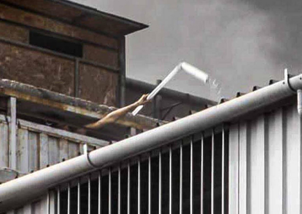 Seorang yang terjebak dalam toko melambaikan tangan minta pertolongan. Sedikitnya empat orang dinyatakan hilang dam empat petugas mengalami luka-luka dalam kebarakan besar ini. 