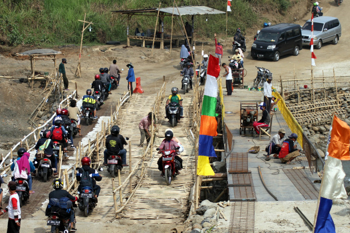 Warga membangun jembatan besi darurat di Cipamingkis, Jonggol, Kabupaten Bogor, Jawa Barat, Jumat (23/6). Warga membangun secara swadaya untuk pengganti jembatan bambu setelah patahnya jembatan Cipamingkis. ANTARA FOTO/Yulius Satria Wijaya