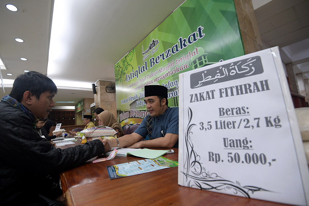 Panitia amil zakat melayani umat muslim yang membayarkan zakatnya di Masjid Istiqlal, Jakarta