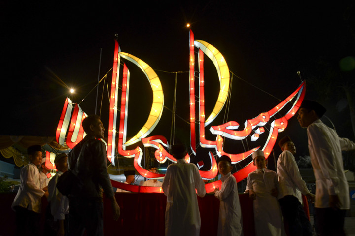 Umat muslim membawa lampion saat mengikuti 