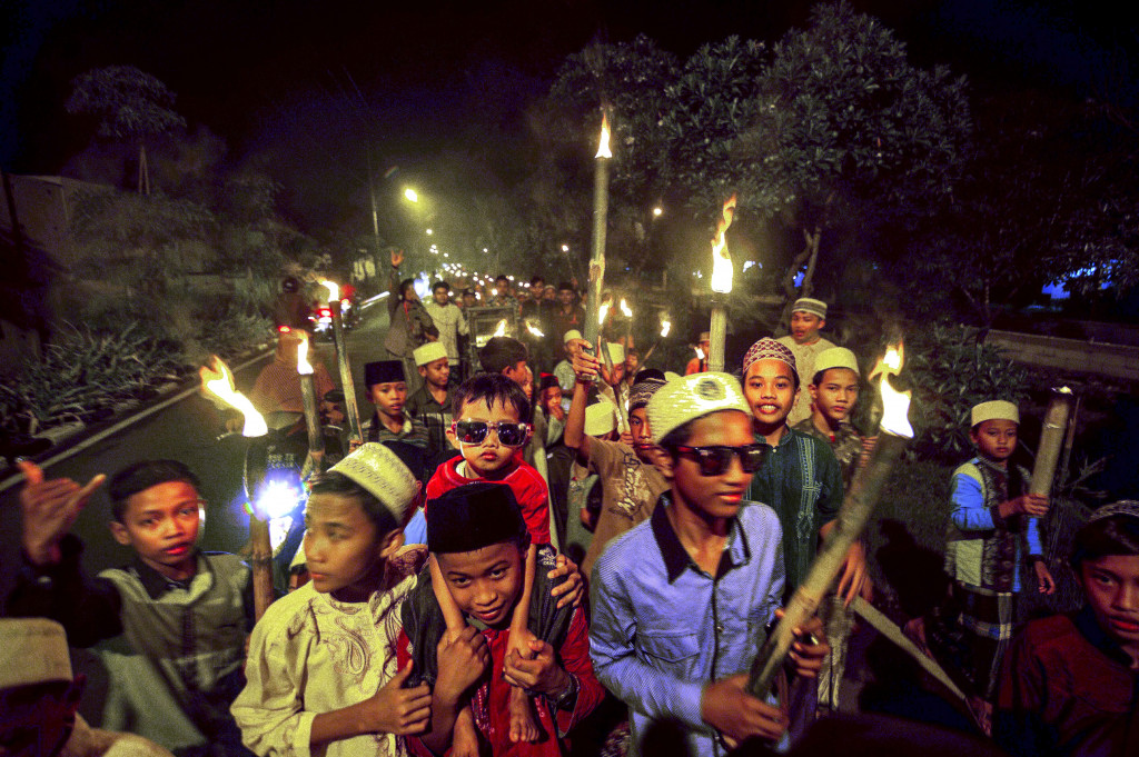 Malam sebelum Salat Ied, umat Islam berkeliling kota sambil menyerukan takbir. Seperti dilakukan serombongan anak-anak di Surabaya ini. Obor yang mereka bawa merupakan simbol terbakar habisnya dosa-dosa umat Islam bila melaksanakan ibadah puasa Ramadan dengan benar. AFP Photo/Juni Kriswanto