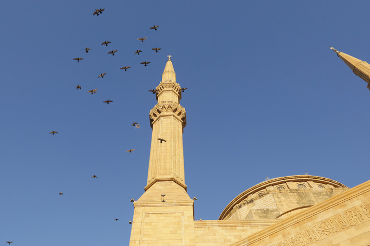 Burung-burung terbang di atas Masjid Mohammad al-Amin di pusat kota Beirut, saat umat muslim melaksanakan salat Idul Fitri.