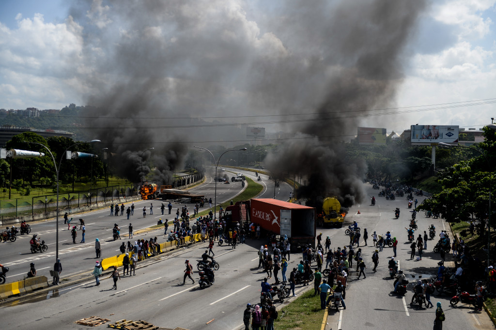 Massa pengunjukrasa memblokade akses jalan jalan utama di Caracas, Venezuela. Presiden Moduro dituding tidak cepat mengatasi krisis ekonomi yang menyebabkan kelangkaan bahan pangan dan obat-obatan. AFP Photo/Federico Parra