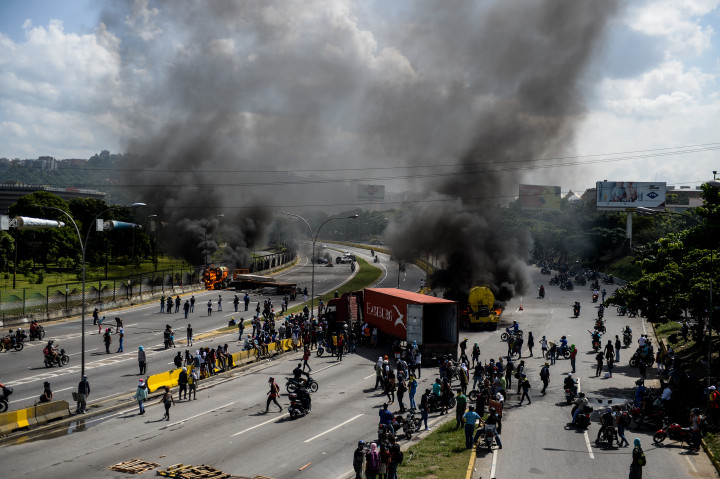 Massa pengunjukrasa memblokade akses jalan jalan utama di Caracas, Venezuela. Presiden Moduro dituding tidak cepat mengatasi krisis ekonomi yang menyebabkan kelangkaan bahan pangan dan obat-obatan. AFP Photo/Federico Parra