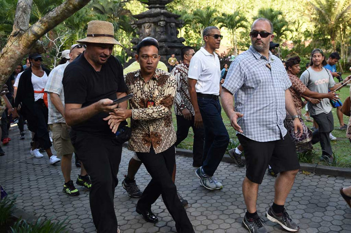 Dengan pengawalan ketat, Presiden ke-44 AS Barack Obama dan keluarga beserta rombongan mengunjungi Pura Tirta Empul, Tampaksiring, Gianyar, Selasa (27/6/2017). AFP/Sonny Tumbelaka
